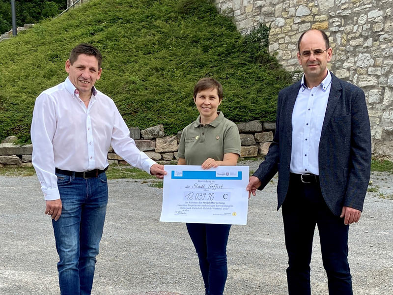 Bürgermeister Andreas Henning (Südeichsfeld), Naturparkleiterin Claudia Wilhelm und Bürgermeister Michael Reinz (Stadt Treffurt) halten den symbolischen Scheck für den TOP-Wanderweg Normannstein in den Händen. Foto: Reiner Schmalzl